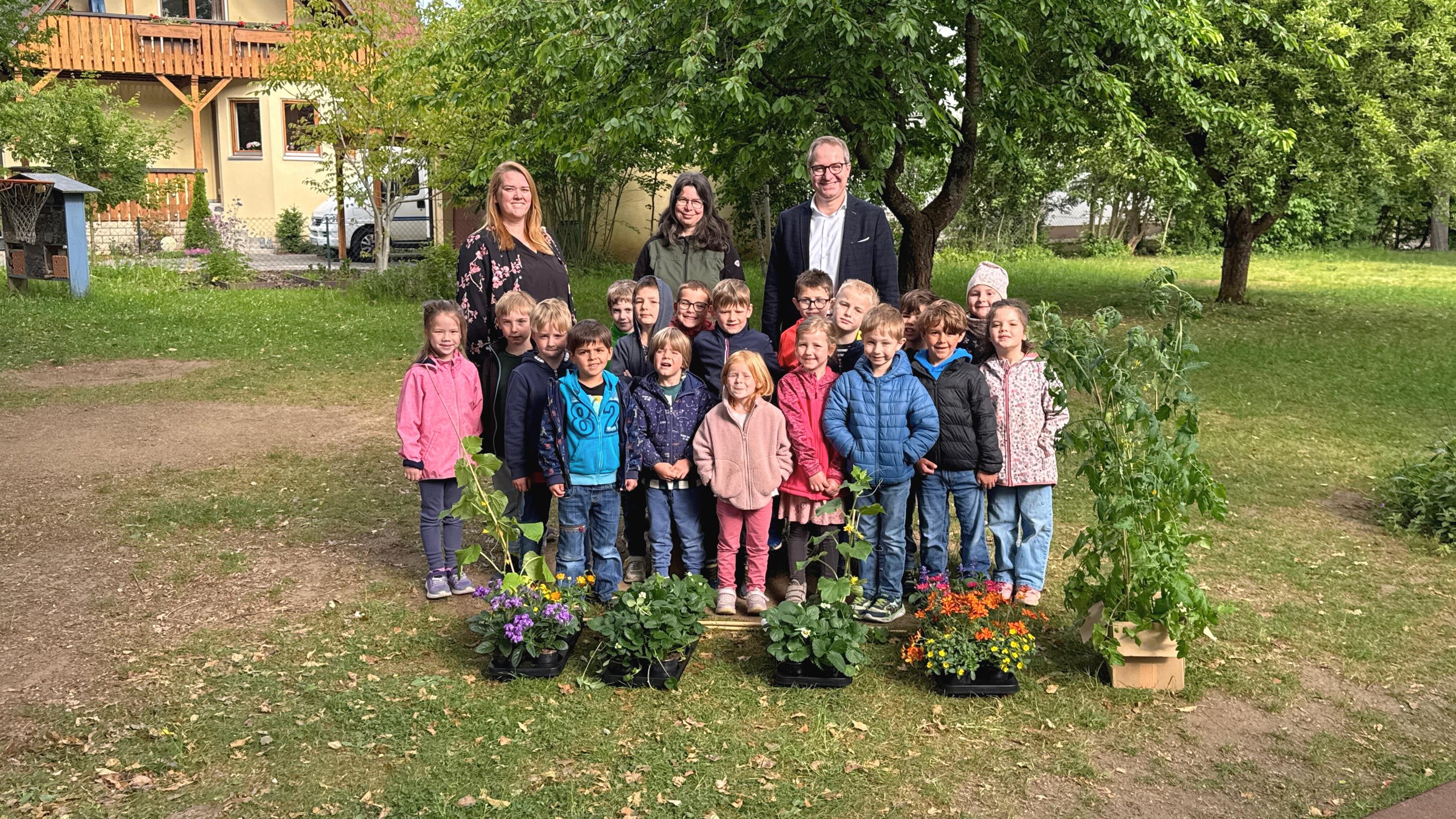 Die Vorschulkinder des Kindergartens St. Martin und Leiterin Katja Rackl (hinten links) freuten sich sehr über die Pflanzen, die Stefanie Scharrer von der Stadtgärtnerei (hinten mittig) und Oberbürgermeister Markus Ochsenkühn (hinten rechts) übergaben.     Foto: Lisa Niebler/Stadt Neumarkt